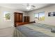 Bedroom with dark wood furniture, ceiling fan, carpet floor and large windows for plenty of natural light at 25606 W Satellite Ln, Buckeye, AZ 85326