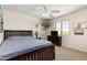 Bedroom with a dark wood bed frame, ceiling fan, and natural light from a window at 25606 W Satellite Ln, Buckeye, AZ 85326