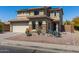 A two-story home with a desert landscape, with stone accents and a two car garage at 25606 W Satellite Ln, Buckeye, AZ 85326