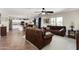 Bright living room with tile flooring, neutral walls, ceiling fan, and modern furnishings, leading to an open kitchen at 25606 W Satellite Ln, Buckeye, AZ 85326