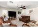 Cozy living room featuring comfortable sofas, a ceiling fan, and a large television at 25606 W Satellite Ln, Buckeye, AZ 85326