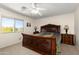 Main bedroom featuring a large bed, ceiling fan, and window with view of exterior landscaping at 25606 W Satellite Ln, Buckeye, AZ 85326