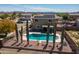 An aerial view of a private pool with desert landscaping and solar panels on this two-story home at 25606 W Satellite Ln, Buckeye, AZ 85326