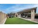 Expansive backyard featuring artificial turf, a covered patio, and a trampoline perfect for outdoor activities at 2822 E Hidalgo Ave, Phoenix, AZ 85040