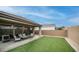 View of backyard featuring artificial turf, a covered patio, comfortable seating, and privacy walls at 2822 E Hidalgo Ave, Phoenix, AZ 85040
