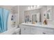 Bright bathroom featuring double sinks, a large mirror, and a shower-tub combo with stylish fixtures at 2822 E Hidalgo Ave, Phoenix, AZ 85040