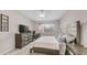 Spacious bedroom with neutral walls, a ceiling fan, large window, and dresser with mounted television at 2822 E Hidalgo Ave, Phoenix, AZ 85040