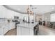 Modern kitchen with a spacious island, white cabinets, stainless steel appliances, and an adjacent dining area at 2822 E Hidalgo Ave, Phoenix, AZ 85040