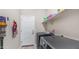 Modern laundry room with front loading washer and dryer, storage shelf, and beige walls at 2822 E Hidalgo Ave, Phoenix, AZ 85040