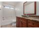 Bathroom with granite vanity, wooden cabinets, tile floors, and a tub-shower combo at 2906 W Irma Ln, Phoenix, AZ 85027