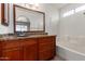 Bathroom featuring a dark wood vanity, granite counters, large mirror and shower/tub combo at 2906 W Irma Ln, Phoenix, AZ 85027