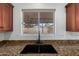 Close up of the sink and granite counter in the kitchen with view of the backyard at 2906 W Irma Ln, Phoenix, AZ 85027