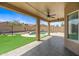Covered back patio with ceiling fan overlooking the pool and landscaped backyard at 2909 W Bowker St, Phoenix, AZ 85041