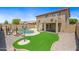 An expansive backyard with lush artificial turf, a sparkling pool, and mature palm trees at 2909 W Bowker St, Phoenix, AZ 85041
