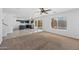 Open-concept living room featuring neutral tones, carpet, and access to the kitchen and backyard at 2909 W Bowker St, Phoenix, AZ 85041