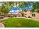Inviting backyard featuring a well-maintained lawn, mature trees, and a cozy patio with seating area at 30266 N Royal Oak Way, San Tan Valley, AZ 85143