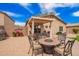 A backyard patio includes brick pavers, an outdoor kitchen and dining area with a fire pit, ideal for entertaining at 30266 N Royal Oak Way, San Tan Valley, AZ 85143