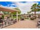 Relaxing backyard patio featuring ample seating, a cozy pergola, lush plants and manicured landscaping at 30266 N Royal Oak Way, San Tan Valley, AZ 85143