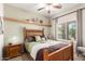 A cozy bedroom features a wooden bed frame, stylish decorations, and a window that brings in natural light at 30266 N Royal Oak Way, San Tan Valley, AZ 85143