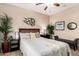 Inviting bedroom with a leafy green plant, window view, a ceiling fan, and a cozy bench offering serene comfort at 30266 N Royal Oak Way, San Tan Valley, AZ 85143