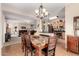 Open dining area with wood-style floors, a marble table, modern chandelier, and a seamless view into the cozy living room at 30266 N Royal Oak Way, San Tan Valley, AZ 85143