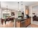 Bright eat-in kitchen features stainless appliances, dark countertops, wooden cabinets, and seamlessly connects to the dining area at 30266 N Royal Oak Way, San Tan Valley, AZ 85143