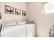 Bright laundry room featuring a modern washer and dryer with a decorative window and cotton artwork on the wall at 30266 N Royal Oak Way, San Tan Valley, AZ 85143