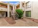 Exterior view of the building with white stairs and orange railings and landscaped common areas at 3119 W Cochise Dr # 111, Phoenix, AZ 85051