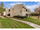 Low angle view of exterior with nice landscaping, and green lawns and a sidewalk leading to the building at 3119 W Cochise Dr # 111, Phoenix, AZ 85051