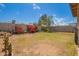 Spacious grassy backyard with a view of mature plants, a wall, and neighborhood trees at 3237 W Angela Dr, Phoenix, AZ 85053