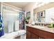 Functional bathroom features a shower-tub combo and vanity with storage cabinets at 3237 W Angela Dr, Phoenix, AZ 85053