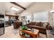 Open concept living room with a high ceiling, view of the kitchen, lots of light, and comfortable seating at 3237 W Angela Dr, Phoenix, AZ 85053