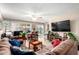 Cozy living room with tile floors, comfortable seating, TV, ceiling fan, and sliding door to outside at 3237 W Angela Dr, Phoenix, AZ 85053