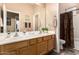Spacious bathroom with a double vanity, large mirror, and separate tub/shower area with a patterned curtain at 3519 E Bridgeport Pkwy, Gilbert, AZ 85295