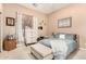 Comfortable bedroom showcasing neutral walls, a cushioned bench, and a bright window dressed with curtains at 3519 E Bridgeport Pkwy, Gilbert, AZ 85295