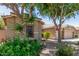 Exterior home view showcasing mature landscaping, partial view of the three-car garage, and charming curb appeal at 3519 E Bridgeport Pkwy, Gilbert, AZ 85295