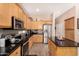 A well-equipped kitchen with stainless steel appliances and ample wooden cabinetry and black countertops at 3519 E Bridgeport Pkwy, Gilbert, AZ 85295
