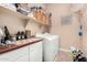 Functional laundry room with tile floor, storage shelves, washer, and dryer at 3519 E Bridgeport Pkwy, Gilbert, AZ 85295