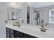 Bathroom featuring double sinks with black hardware and a large mirror with a view of the glass-enclosed shower at 3687 E Leslie Dr, Gilbert, AZ 85296
