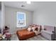 Cozy bedroom with a window and a decorative ceiling design, complemented by a cute pink chair at 3687 E Leslie Dr, Gilbert, AZ 85296