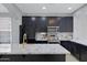 Modern kitchen featuring black cabinets, stainless steel appliances and a large island with stone countertop at 3687 E Leslie Dr, Gilbert, AZ 85296