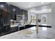 Modern kitchen featuring black cabinets, stainless steel appliances, and a granite countertop island with a gold faucet at 3687 E Leslie Dr, Gilbert, AZ 85296