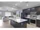 Modern kitchen featuring black cabinets, stainless steel appliances and a large island with stone countertop at 3687 E Leslie Dr, Gilbert, AZ 85296