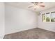 Bright bedroom showcasing tile floors, ceiling fan, and window with charming shutters at 3710 E Mercer Ln, Phoenix, AZ 85028