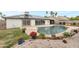 Landscaped backyard with a sparkling blue pool, solar panels, and mature trees offering a private outdoor retreat at 3973 W Hearn Rd, Phoenix, AZ 85053