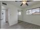 Bedroom features hardwood floors, a ceiling fan and a view of the front yard through a large window at 3973 W Hearn Rd, Phoenix, AZ 85053