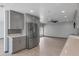 Bright, renovated kitchen with stainless steel appliances and gray cabinetry, seamlessly flowing into the living space at 3973 W Hearn Rd, Phoenix, AZ 85053