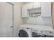 Functional laundry room with upper cabinets and modern appliances, designed for convenience and organization at 3973 W Hearn Rd, Phoenix, AZ 85053