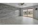 Bright living room features a decorative accent wall, ceiling fan, and sliding door leading to the backyard pool at 3973 W Hearn Rd, Phoenix, AZ 85053