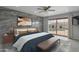 Bedroom with a view of the pool, wooden nightstands, bench, ceiling fan, and gray accent wall at 3973 W Hearn Rd, Phoenix, AZ 85053